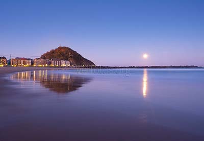 Amanecer con luna llena sobre la playa de la Zurriola, ciudad de Donostia-San Sebastián, Euskadi
