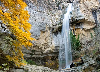Cascada junto a un arbol con colores de otoño en Artazul, valle de Ollo, Navarra