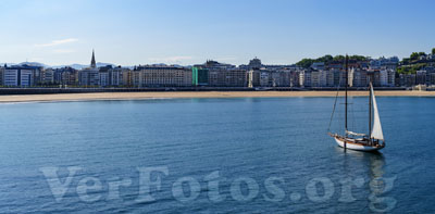 En la hermosa ciudad de Donostia, un velero surca las aguas del mar frente a la icónica playa de la Concha