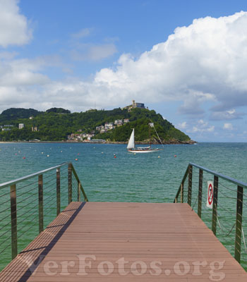 En la hermosa ciudad de Donostia-San Sebastián,, un velero se mece suavemente frente al embarcadero de la bahía de la Concha, creando una imagen idílica que invita a disfrutar del lugar,  Euskadi